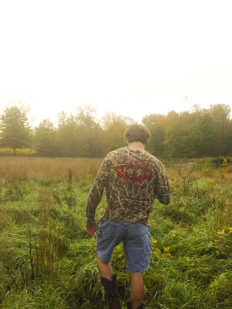 Camo button-up worn in a field, red crown of thorns on back