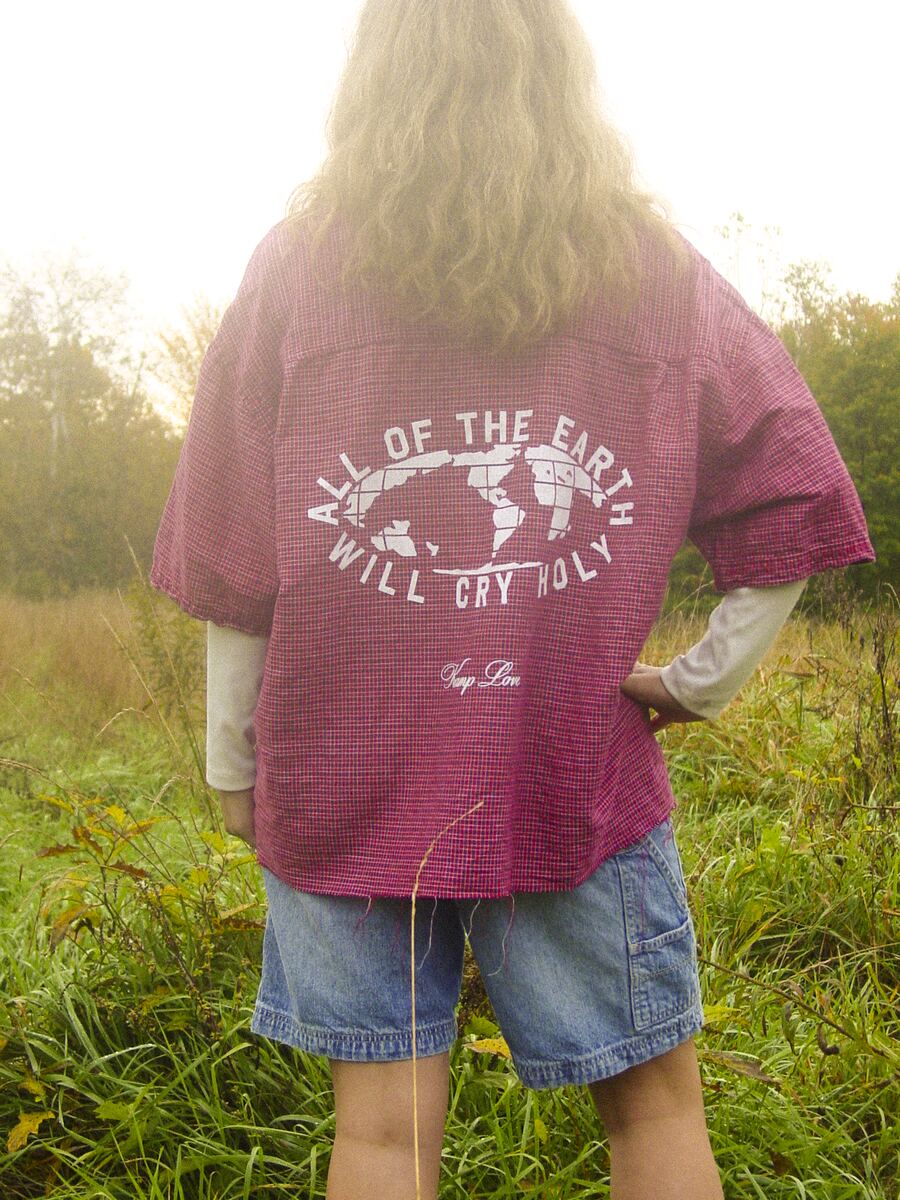 Pink tee, back print: All of the Earth Will Cry Holy around a globe